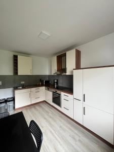 una cucina con armadietti bianchi e frigorifero bianco di Wohnung für Monteure (Einzelzimmer / Doppelzimmer) in der Nähe von Köln/Bonn/Hennef/Waldbröl a Waldbröl