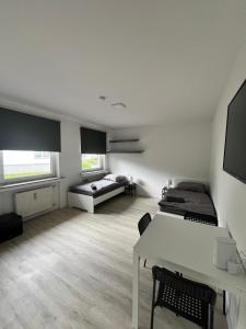 Habitación con 2 camas y mesa. en Wohnung für Monteure (Einzelzimmer / Doppelzimmer) in der Nähe von Köln/Bonn/Hennef/Waldbröl en Waldbröl