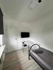 una camera con letto e scrivania con TV di Wohnung für Monteure (Einzelzimmer / Doppelzimmer) in der Nähe von Köln/Bonn/Hennef/Waldbröl a Waldbröl