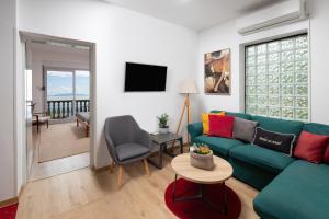 a living room with a green couch and a table at Apartments Green Garden in Opatija
