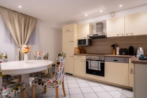 a kitchen with a table and chairs and a stove at EPA Apartment - Swedish style Souterrain in Rust +5 photos