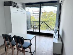 布宜諾斯艾利斯的住宿－Apart Lola，一个带桌椅的厨房和一个阳台