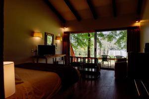 een slaapkamer met een bed en een glazen schuifdeur bij Hotel Salto Del Laja in Los Ángeles