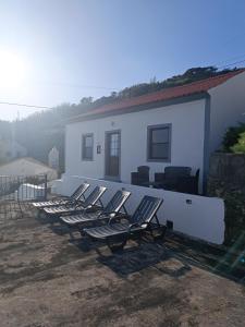 a row of chairs sitting outside of a house at Alojamento Local M&I in Lajes das Flores