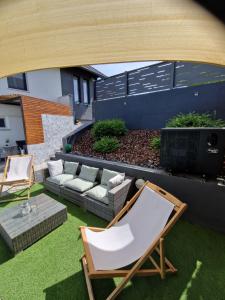 a patio with a couch and chairs on the grass at Aura Lux Holiday Home with Pool in Lopatinec