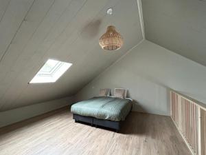 a attic bedroom with a bed and a light at Buitenplaats Ureterp in Ureterp