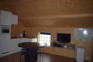 a kitchen with a table and a television on a wall at Lî Stôle in Durbuy