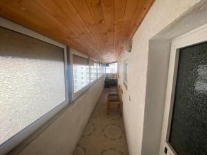 einen leeren Flur mit Fenster und Stuhl in der Unterkunft Aparttamento in Tirana