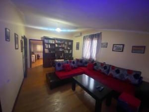 ein Wohnzimmer mit einem roten Sofa und einem Tisch in der Unterkunft Aparttamento in Tirana