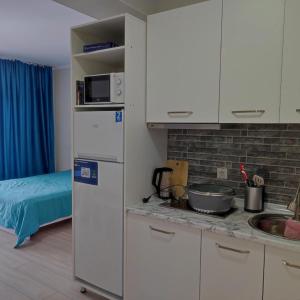a kitchen with a white refrigerator and a sink at Townhouse 4/11 in Bosteri