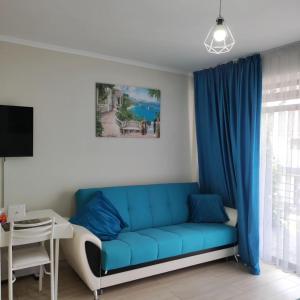 a living room with a blue couch and a table at Townhouse 4/11 in Bosteri