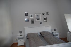 Schlafzimmer mit einem Bett mit Bildern an der Wand in der Unterkunft B2-Ferienwohnung in Erfurt