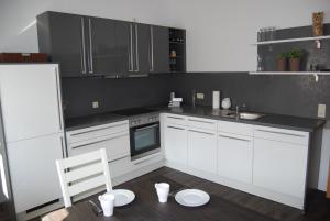 eine Küche mit weißen Schränken und einem weißen Stuhl darin in der Unterkunft B2-Ferienwohnung in Erfurt