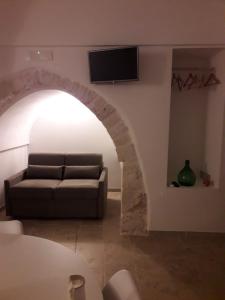 sala de estar con sofá y TV en la pared en Le Chianche, en Ceglie Messapica