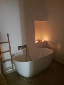 bañera blanca en una habitación con luz en Le Chianche, en Ceglie Messapica