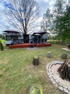 a house with tables and chairs in a yard at Ostoja in Lucień