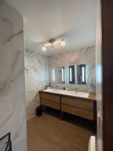 a bathroom with a sink and a large mirror at B&B Le Bouchat-Oreille in Spontin