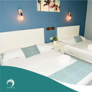 Monte Gordo的住宿－Hotel Bungalows Marbella Costa Esmeralda，蓝色墙壁客房的两张床