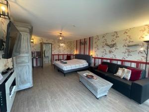 a living room with a couch and a bed at B&B Le Bouchat-Oreille in Spontin