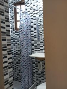 a bathroom with a shower curtain and a sink at Casa famíliar agradável in Rio de Janeiro