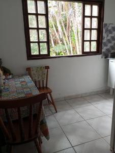 a kitchen with a table and chairs and a window at Casa famíliar agradável in Rio de Janeiro