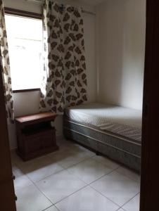 a small bedroom with a bed and a window at Casa famíliar agradável in Rio de Janeiro +6 photos