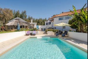 a swimming pool in front of a house at Villa Azul, Graça Portugal in Pedrógão Grande