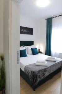 um quarto com uma cama grande e detalhes em azul em Airport Belgrade Apartments em Surčin