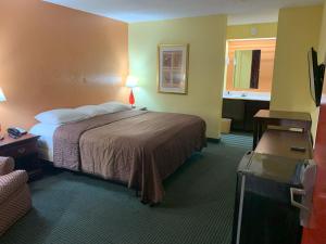 ダブリンにあるRelax Inn & Suitesのベッドとバスルーム付きのホテルルームです。