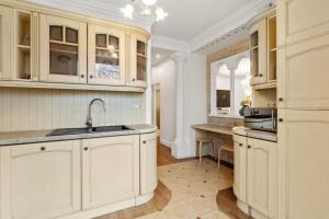 a kitchen with white cabinets and a sink at Großes Apartment in bester Lage nahe Wien in Baden +10 photos