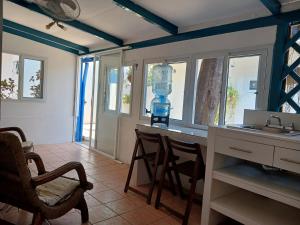 een keuken met een aanrecht met stoelen en een wastafel bij Hostel SaltWater in San Juan del Sur
