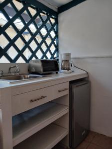 a kitchen with a sink and a counter top at Hostel SaltWater in San Juan del Sur