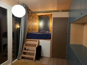 um pequeno quarto com uma cama e uma escada em A tiny house close to nature - Amsterdam region em Lelystad