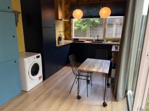a kitchen with a table and a washing machine at A tiny house close to nature - Amsterdam region in Lelystad