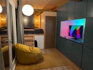a living room with a tv and a couch in a room at A tiny house close to nature - Amsterdam region in Lelystad