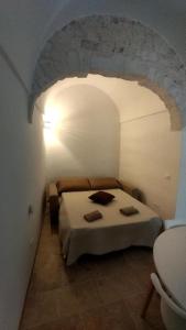 1 dormitorio con 1 cama en una habitación blanca en Le Chianche, en Ceglie Messapica
