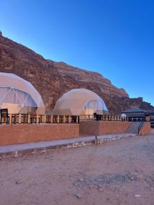 two domes on a building with a mountain in the background at Obeid's Bedouin Life Camp in Wadi Rum