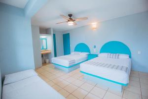 a bedroom with two beds and a ceiling fan at Hotel Bungalows Marbella Costa Esmeralda in Monte Gordo +54 photos