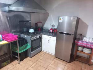 uma cozinha com um frigorífico de aço inoxidável e um fogão em SajaHome em Cusco