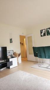 - un salon avec une télévision et un canapé dans l'établissement Appartement proche de l'aéroport CDG & stade de France, à Aulnay-sous-Bois