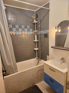 La salle de bains est pourvue d'une baignoire et d'un lavabo. dans l'établissement Appartement proche de l'aéroport CDG & stade de France, à Aulnay-sous-Bois