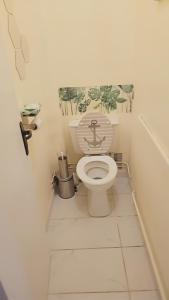 La salle de bains est pourvue de toilettes avec un singe sur le couvercle. dans l'établissement Appartement proche de l'aéroport CDG & stade de France, à Aulnay-sous-Bois