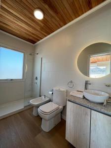 un bagno con un water, un lavandino e uno specchio di El Campito Tiny House de lujo a Rodeo