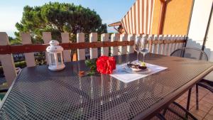 un tavolo con un piatto di cibo e una rosa rossa di Cappuccini Appartments a Peschiera del Garda