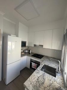 サン・ハビエルにあるLa casika de Lolaの白い冷蔵庫とシンクのあるキッチン