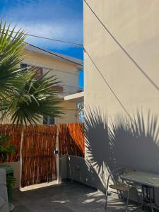 une terrasse avec une table, une clôture et un palmier dans l'établissement CreteSuites - Urban Villa with Pool - 500m to the Beach, à Réthymnon