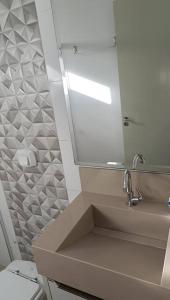 bagno con lavandino, specchio e servizi igienici di Casa aconchegante Gran Ville a Rondonópolis