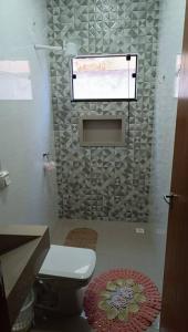 baño pequeño con aseo y ventana en Casa aconchegante Gran Ville, en Rondonópolis