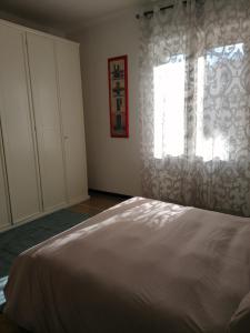 - une chambre avec un lit blanc et une fenêtre dans l'établissement La casa di Rossella - Genova, Quarto mare, à Gênes