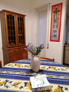une table avec un vase avec des fleurs au-dessus dans l'établissement La casa di Rossella - Genova, Quarto mare, à Gênes